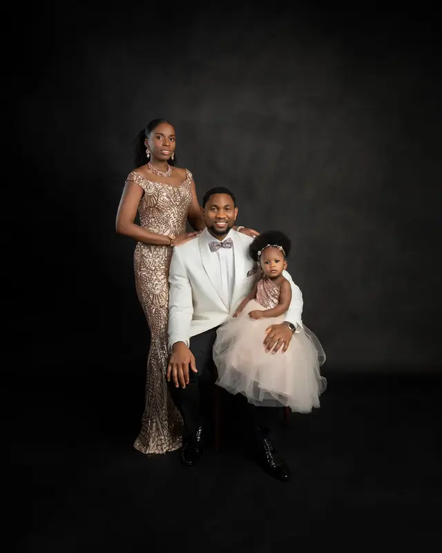 Dr. Guiste with her husband and their young daughter in a studio family portrait